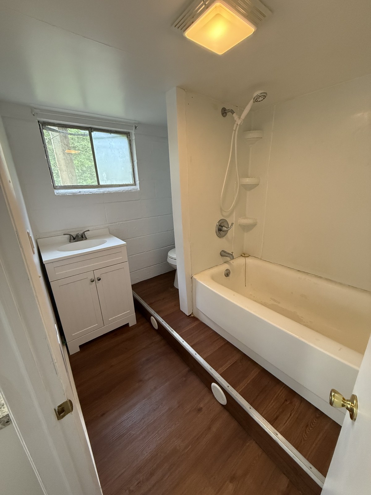 One-bedroom apartment bathroom with tub and vanity