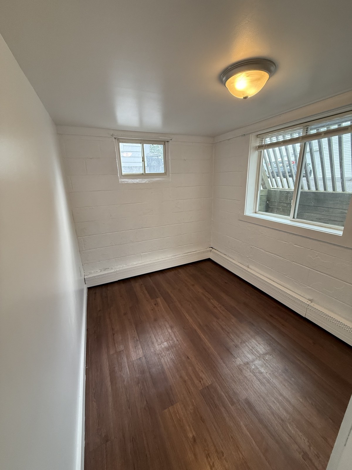 One-bedroom apartment bedroom with wood floor and windows